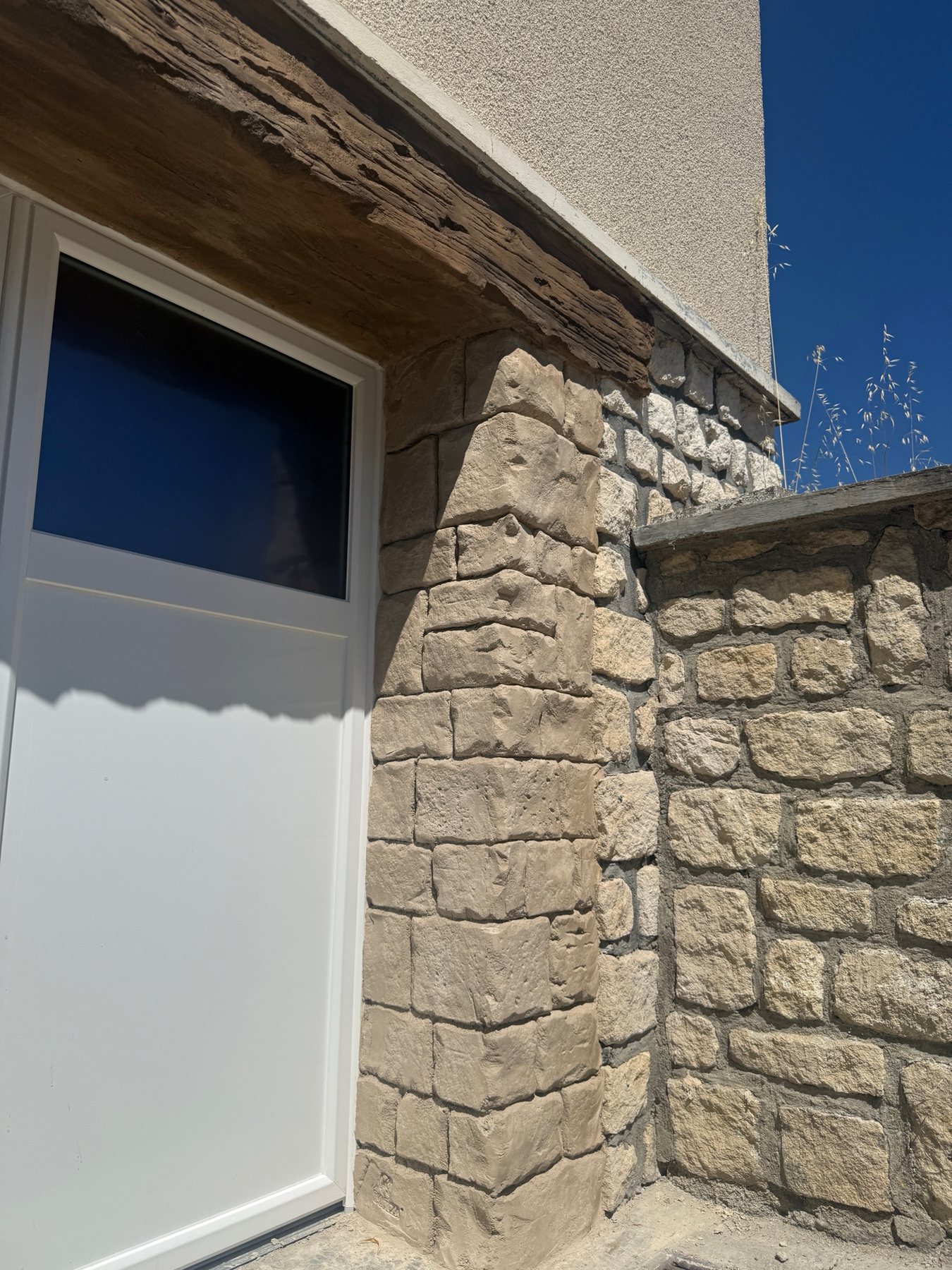 Réalisation extérieure IMULTEZA : angle de façade en imitation pierre autour d'une porte